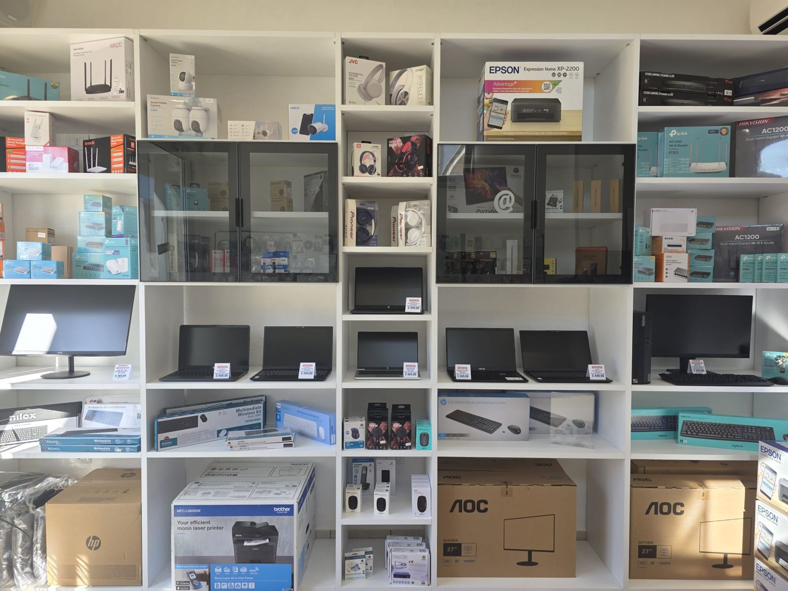 Gli scaffali del negozio PC System con notebook, monitor, stampanti e router